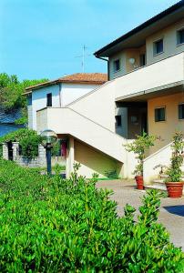 a house with a yard with plants in front of it at Elbamar Marina Di Campo in Marina di Campo