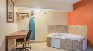een badkamer met een bureau en een bad bij Rodeway Inn & Suites in Lakeview +39 foto's