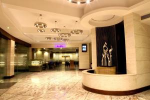 a lobby with a fountain in the middle of a building at Lords Plaza Surat in Surat