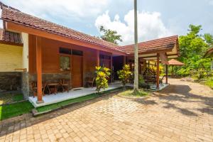 een huis met een bakstenen patio ervoor bij G Beach Hotel in Grajagan