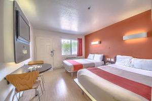 a hotel room with two beds and a desk at Motel 6 San Antonio, Tx Six Flags Fiesta TX - La Cantera Area in San Antonio +48 photos