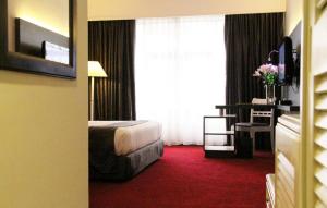 a hotel room with a bed and a window at Grand Riverview Hotel in Kota Bharu