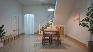 ein Esszimmer mit einem Tisch und ein paar Treppen in der Unterkunft บ้านใจฟู URBAN HOMe in Mukdahan
