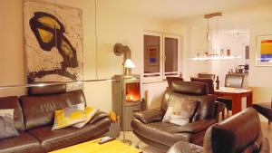 a living room with two leather chairs and a couch at Deichhaus Boddentraum in Breege