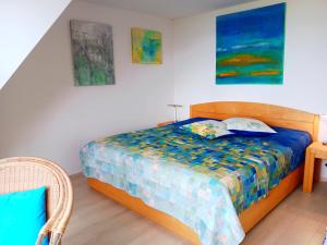 a bedroom with a bed and two paintings on the wall at Deichhaus Boddentraum in Breege