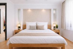 een slaapkamer met een groot bed met twee nachtkastjes bij Comfort 66 Large Family City Home in Miskolc