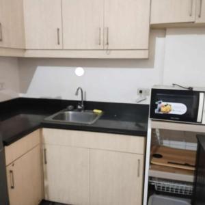una cucina con lavello e microonde di Staycation Condo in Manila a Manila