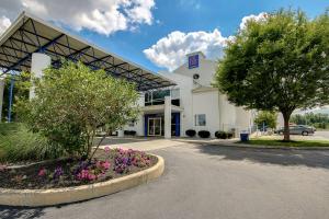 a large white building with a tree in front of it at Motel 6-King Of Prussia, PA - Philadelphia in King of Prussia