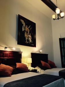 1 dormitorio con 2 camas y un cuadro en la pared en Hotel San Xavier en Querétaro