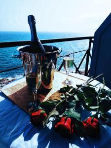 a table with a bottle of wine and two glasses at Queens Leriotis Hotel in Piraeus