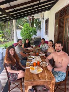een groep mensen die rond een houten tafel zitten bij Samaro Resort in Mirissa +91 foto's