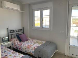 een slaapkamer met twee bedden en twee ramen bij Los tres castells in La Senia
