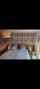 ein Schlafzimmer mit einem Bett mit zwei Kissen in der Unterkunft La longère Saint-Eloi 