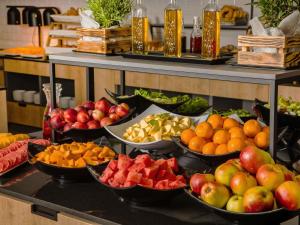 un buffet con molte ciotole di frutta e verdura di Novotel Kraków City West a Cracovia