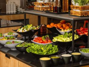 un buffet pieno di ciotole di frutta e verdura di Novotel Kraków City West a Cracovia Altre 22 foto