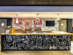 een bar met een muur bedekt met graffiti bij ibis Leeds Centre Marlborough Street in Leeds