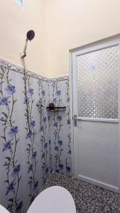 bagno con doccia e fiori blu sul muro di Dream Homestay Sidemen a Silebeng