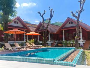 a house with a swimming pool and chairs and umbrellas at Tangerine Villa Patong in Patong Beach