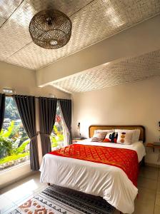 ein Schlafzimmer mit einem Bett und einem großen Fenster in der Unterkunft Little Munduk, full private villa in Munduk