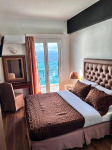 a bedroom with a large bed and a large window at Queens Leriotis Hotel in Piraeus