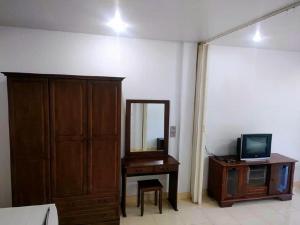 a room with a mirror and a dresser and a television at Pharos Apartments in Nathon Bay