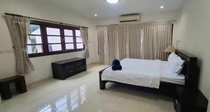a bedroom with a bed with a cat sitting on it at Pharos Apartments in Nathon Bay