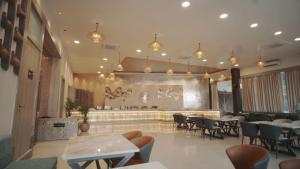 a restaurant with tables and chairs and a bar at The Riverside Inn in Vidisha