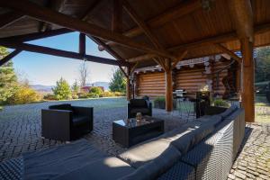 a covered patio with a couch and chairs and a table at Srub Eden in Frýdek-Místek