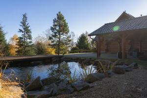 a pond in front of a log cabin at Srub Eden in Frýdek-Místek