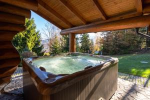 a hot tub on a deck with a wooden roof at Srub Eden in Frýdek-Místek