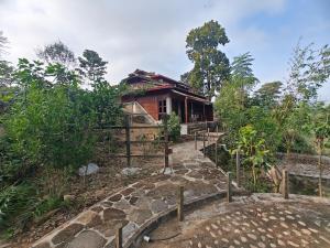 een huis op een heuvel met een pad dat er naar toe leidt bij Himalchuli Nature Farmstay in Bhagaura