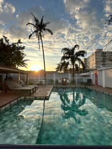 a large swimming pool with palm trees on a building at LAAR Hotel in Praia Grande