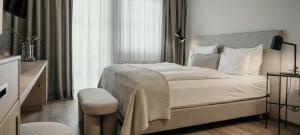 ein Hotelzimmer mit einem Bett und einem Stuhl in der Unterkunft Sonnhof Alpendorf - an adults only place in St. Johann im Pongau