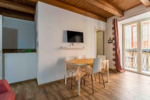 een eetkamer met een tafel, stoelen en een televisie bij Cefalù Center Apartments in Cefalù