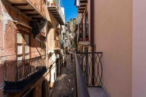 een steeg tussen twee gebouwen met balkons bij Cefalù Center Apartments in Cefalù