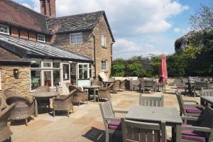 a patio with tables and chairs in front of a building at Princess's Palace, Holiday Lodge, Malvern View Leisure Park in Stanford Bishop