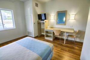 een hotelkamer met een bed en een bureau met een televisie bij Motel 6-Portsmouth, NH in Portsmouth