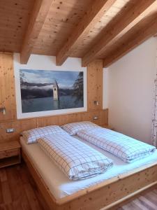 a bedroom with a large bed in a wooden room at Pferdehof Ansteingut in Sluderno