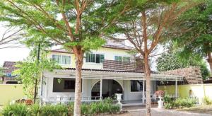 una casa con due alberi davanti di OYO 674 Greenery Home a Ban Nam Sai