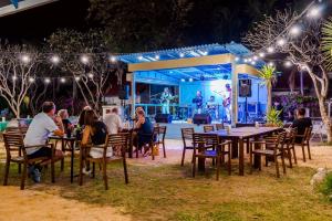 een groep mensen die aan tafels voor een podium zitten bij The Beach Village Resort in Sam Roi Yot +235 foto's