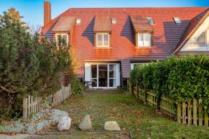 a house with an orange roof and a yard at Haus Wittow in Breege
