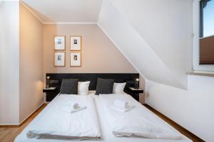 a bedroom with a large bed with white sheets at Haus Wittow in Breege