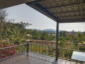 a balcony with a view of a field at The Green Vale B&B in Ban Na Chaliang
