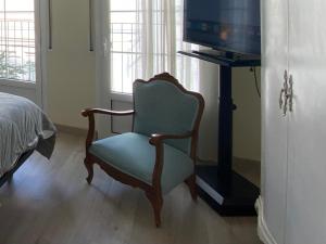 een woonkamer met een stoel en een televisie bij Los tres castells in La Senia