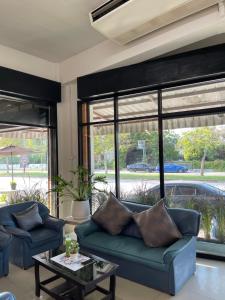 ein Wohnzimmer mit zwei blauen Sofas und einem Tisch in der Unterkunft ท่าบูรพาวิลล่า ที่พักพร้อมสระน้ำ ทั้งหลัง in Ban Hua Khao Sammuk