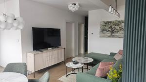 a living room with a couch and a flat screen tv at Luxury Opus Osijek - Self Check in, Free Private Parking in Osijek