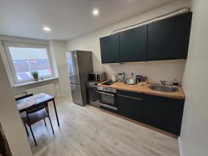 a kitchen with a sink and a table with a table at Studio IT on Tumo in Plungė