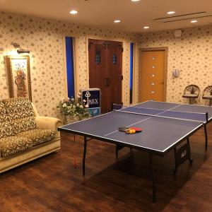 ein Zimmer mit einer Tischtennisplatte und einem Sofa in der Unterkunft Hotel Miyama in Chichibu