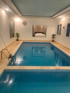 a large swimming pool in a room at فيلا المنزل in Makkah