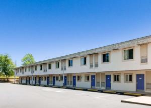 a long white building with blue doors on a street at Motel 6-Statesville, NC in Statesville